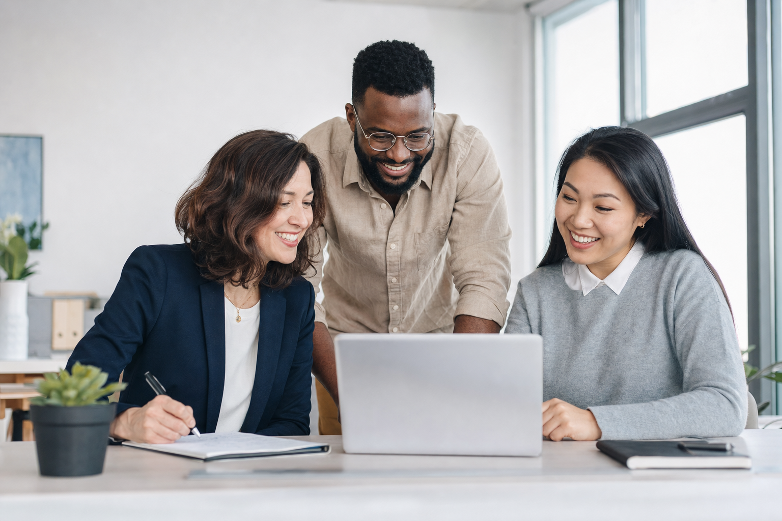Team members collaborating at a laptop