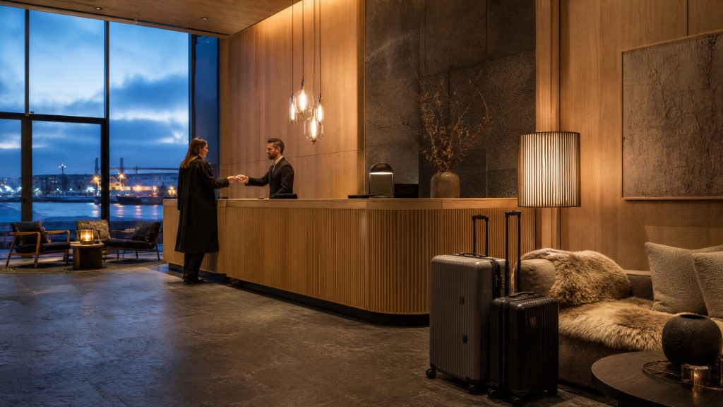 Guest checking into a premium Reykjavík hotel lobby overlooking the harbor