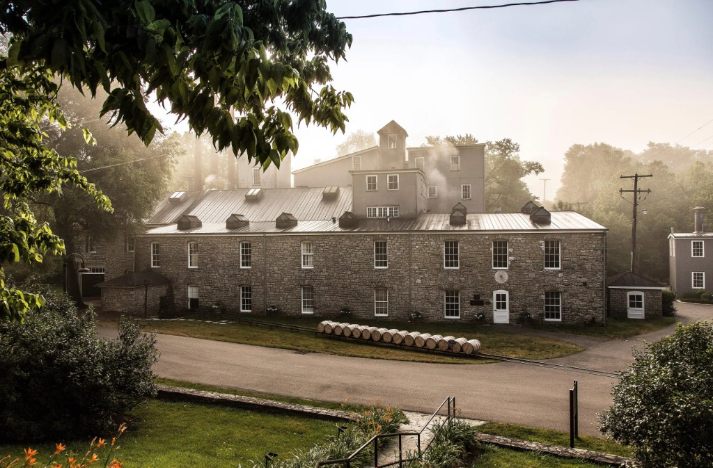 Misty view of stone distillery building with aging barrels