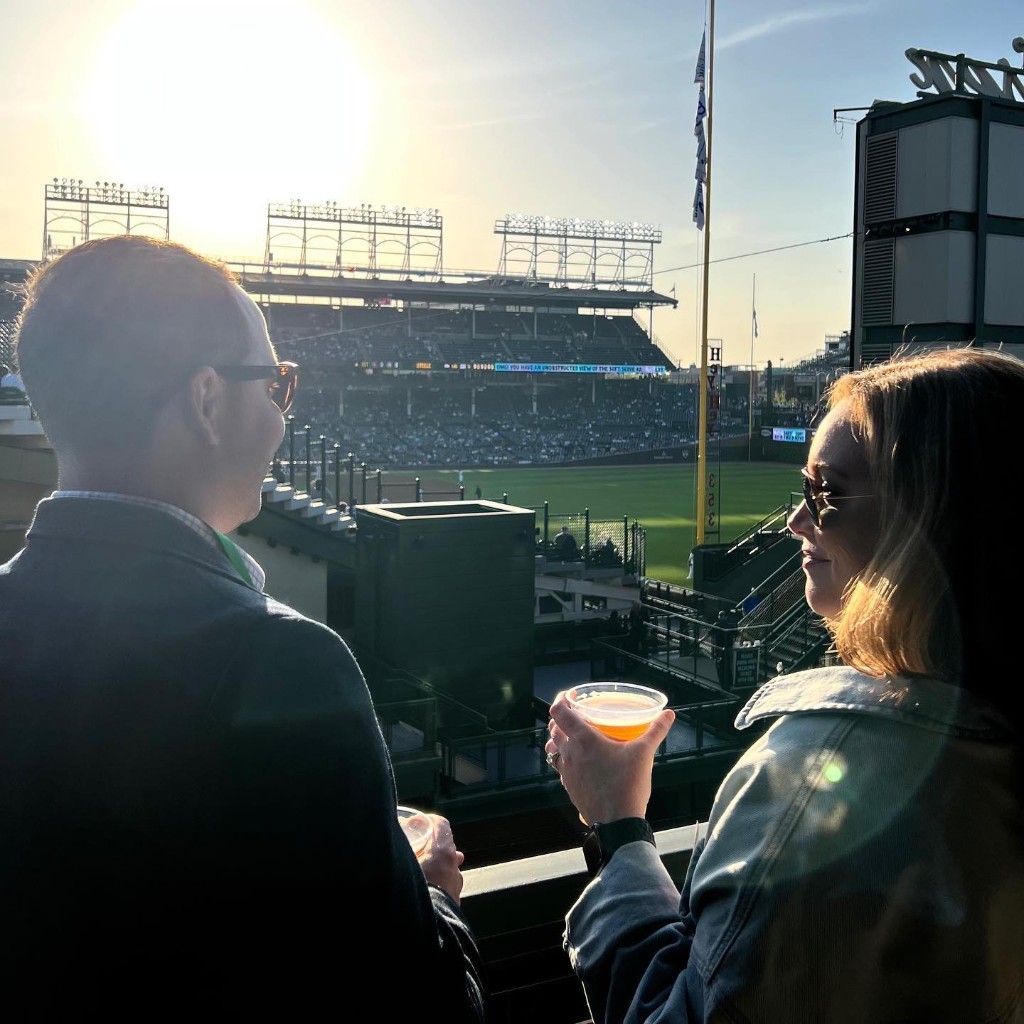 Wrigley Field rooftop view at sunset with Cubs game